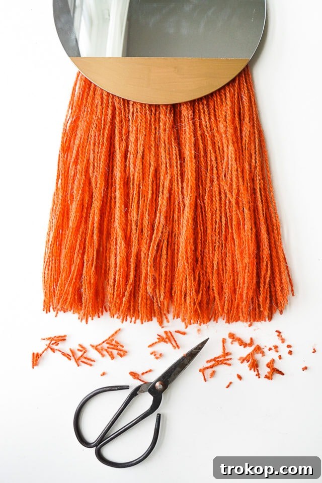 Step 8: Final trimming and fluffing of the yarn fringe for a clean, finished look.