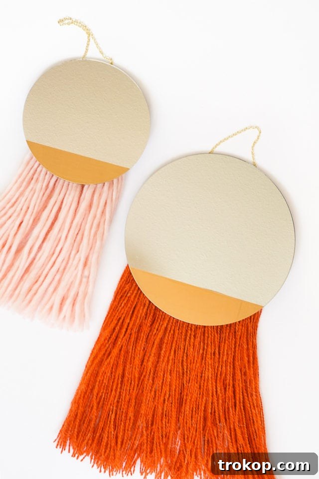 Collection of materials laid out for the DIY Fringed Mirror project including yarn, mirror, paint, and chain.