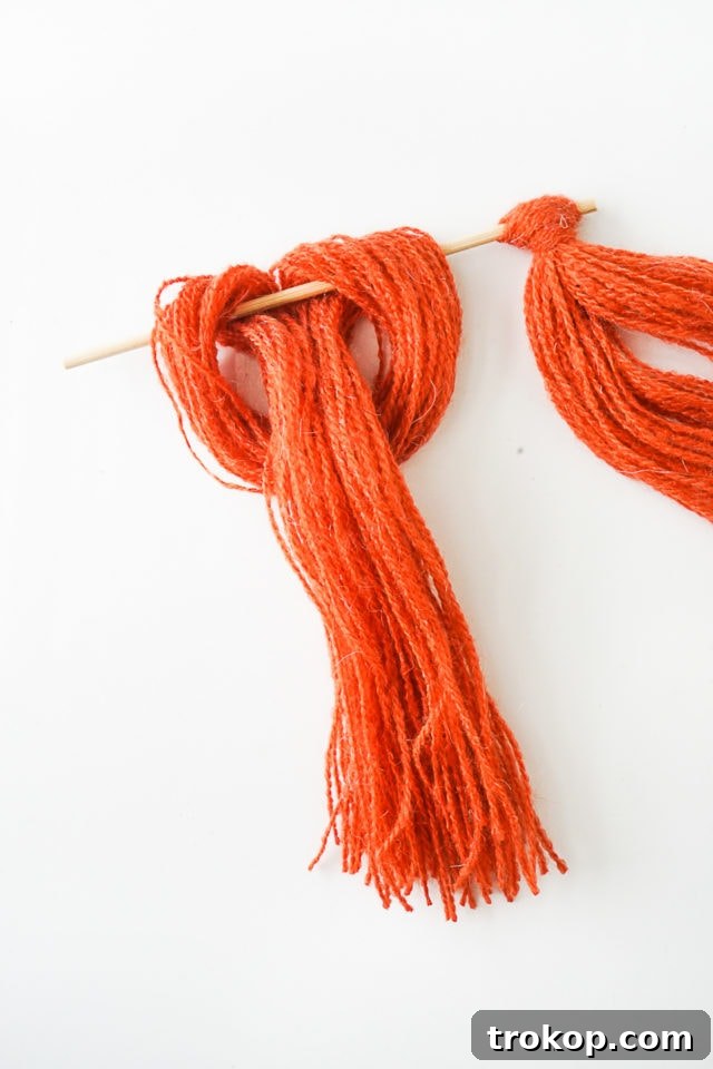 Step 4: All yarn bundles tied to the wooden skewer, forming a dense fringe.