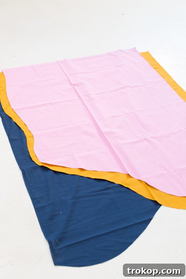 Close-up of fabric samples laid out for a DIY wall hanging project, showcasing various colors and textures