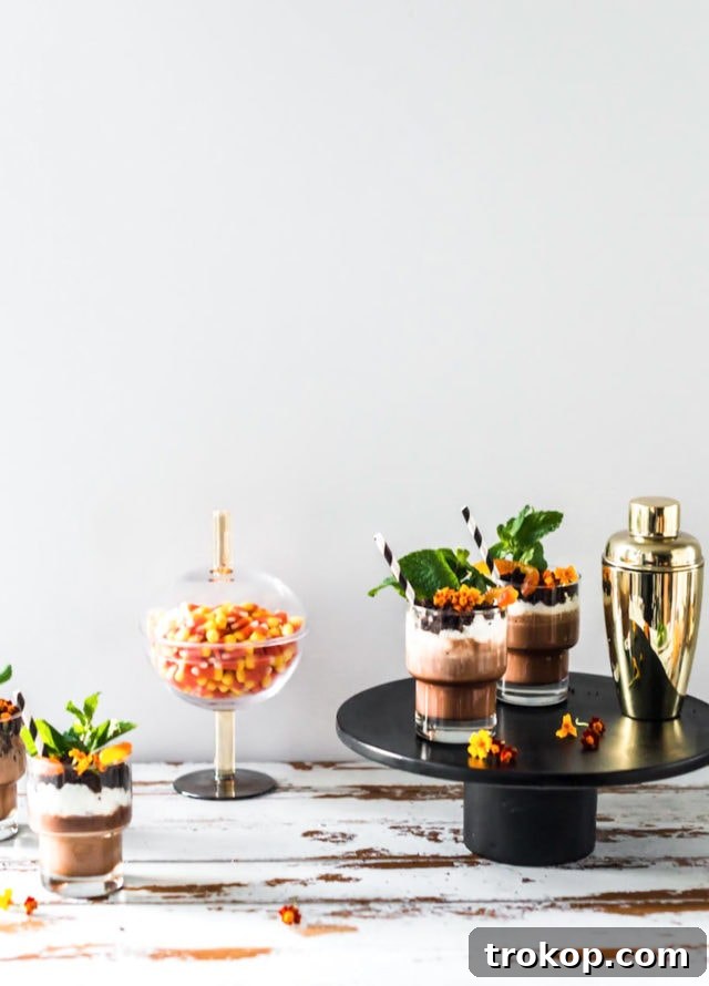 Close-up of Boozy Dirt Cups adorned with mint and edible flowers