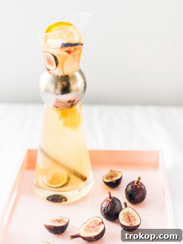 Autumn Fig Apple Cider Sangria 3 Close-up of a glass of Autumn Fig Sangria, garnished with fresh figs and cinnamon sticks, reflecting the vibrant colors of fall.