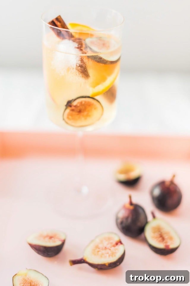 Autumn Fig Apple Cider Sangria 7 Beautifully arranged glasses of Fig Apple Cider Sangria on a wooden surface, ready to be served at an autumn gathering.