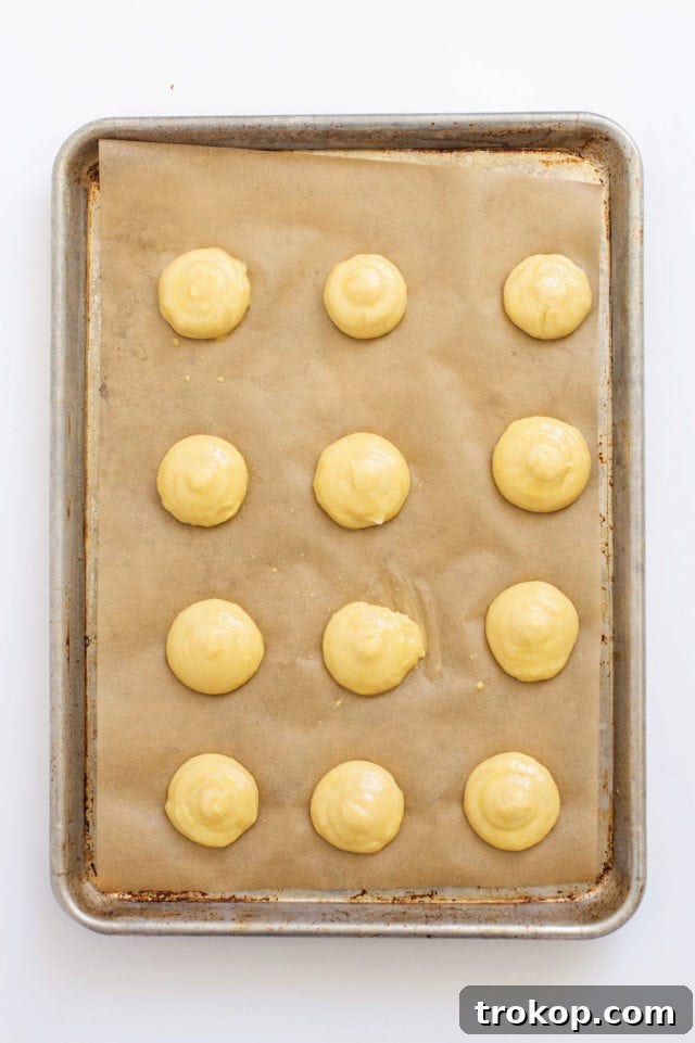Pumpkin Spice Cream Puffs 7 Piping choux pastry dough onto a baking sheet
