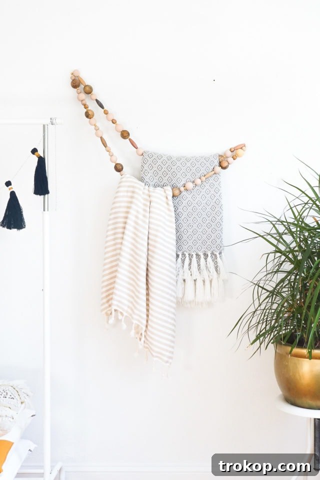 A beautifully decorated room featuring the DIY Minimal Beaded Blanket Holder on the wall, holding several blankets.