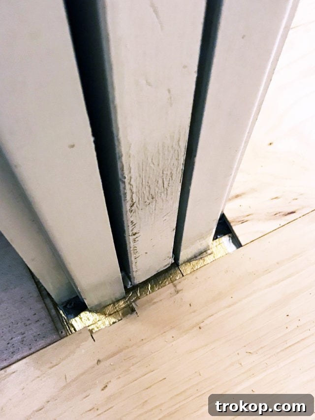 Damaged and poorly installed flooring after the first contractor's attempt, showing chaos and misalignment