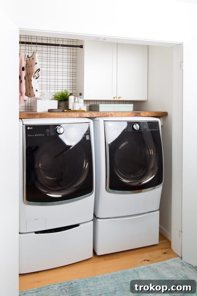 The newly renovated laundry room, showcasing fresh white walls, new cabinetry, and the improved flooring