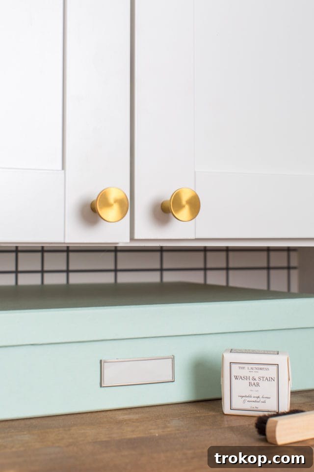 A closer look at the elegant gold door pulls and newly installed slab doors in the renovated laundry room