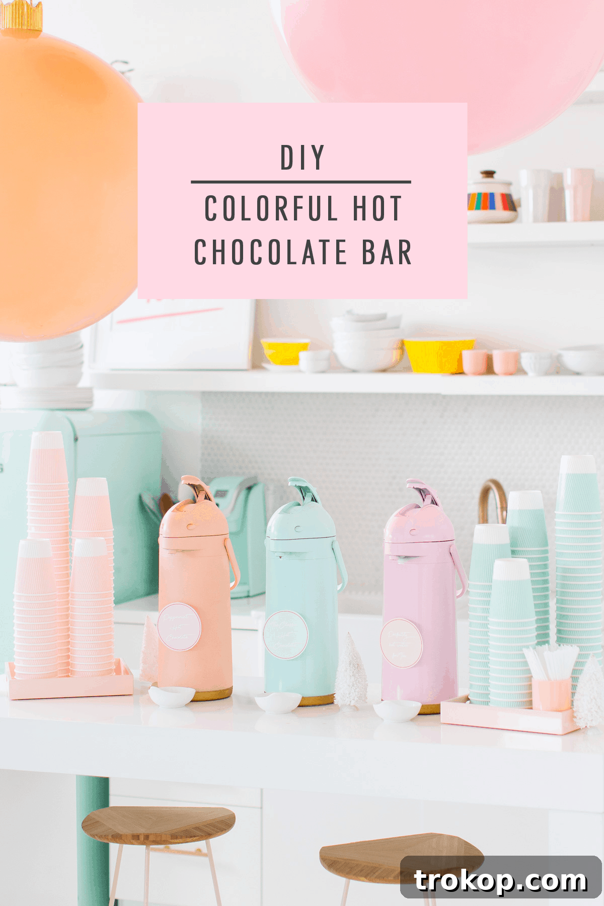 Overhead shot of a beautifully presented DIY hot chocolate station with various toppings and colorful serving ware.