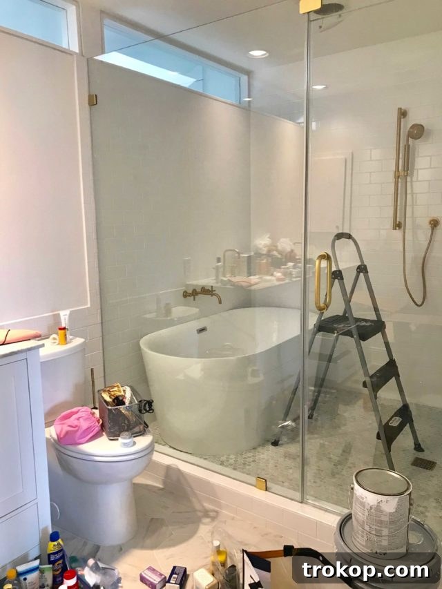 Final Preview Before the Townhouse Unveiling 5 Modern Metrie door with gold Emtek hardware and gold fleck wallpaper in a master bedroom