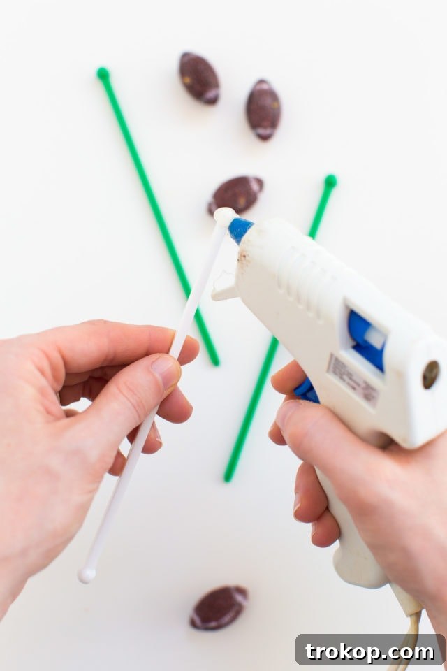 3 Game-Changing Ideas for Your Football Watch Party 5 Close-up of DIY Football Drink Stirrers in beverages, showcasing simple and festive football watch party decor by Ashley Rose of Sugar & Cloth.