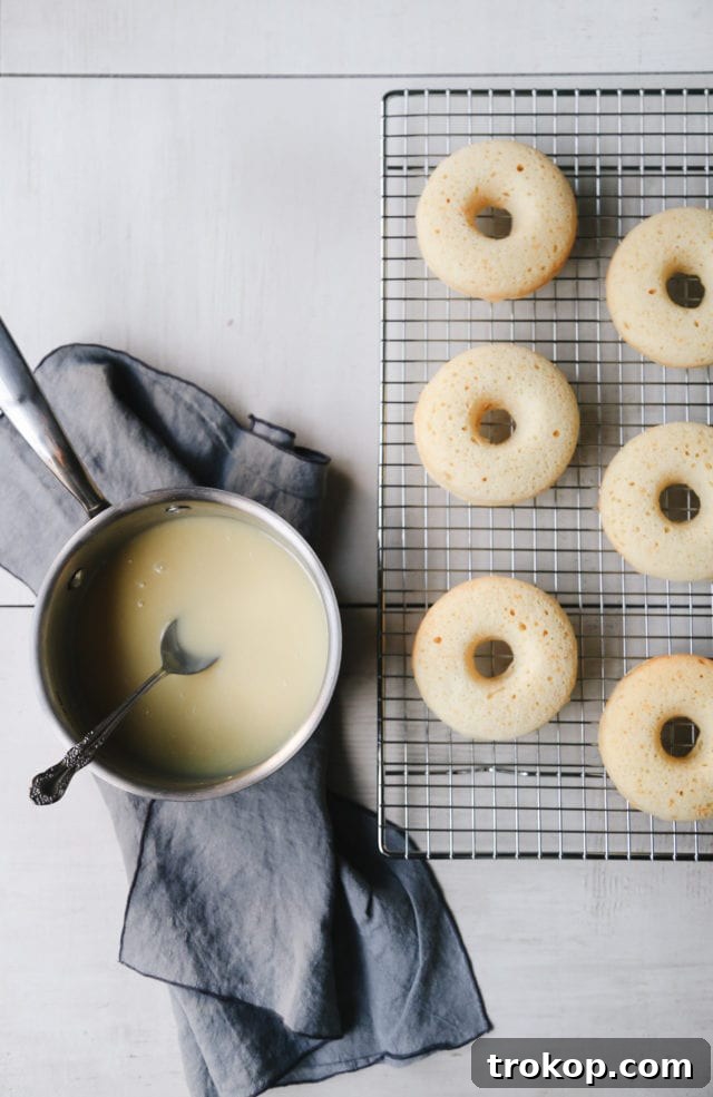 Champagne Infused Doughnuts with Velvety White Chocolate Glaze 7 Freshly baked Champagne Donuts cooling on a wire rack by Ashley Rose of Sugar and Cloth