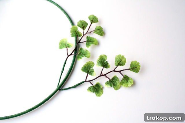 Shimmering Gold DIY: Wreaths & Garlands 9 Step 4: Bending a prepared leaf pair around the floral-taped metal ring for wreath assembly.