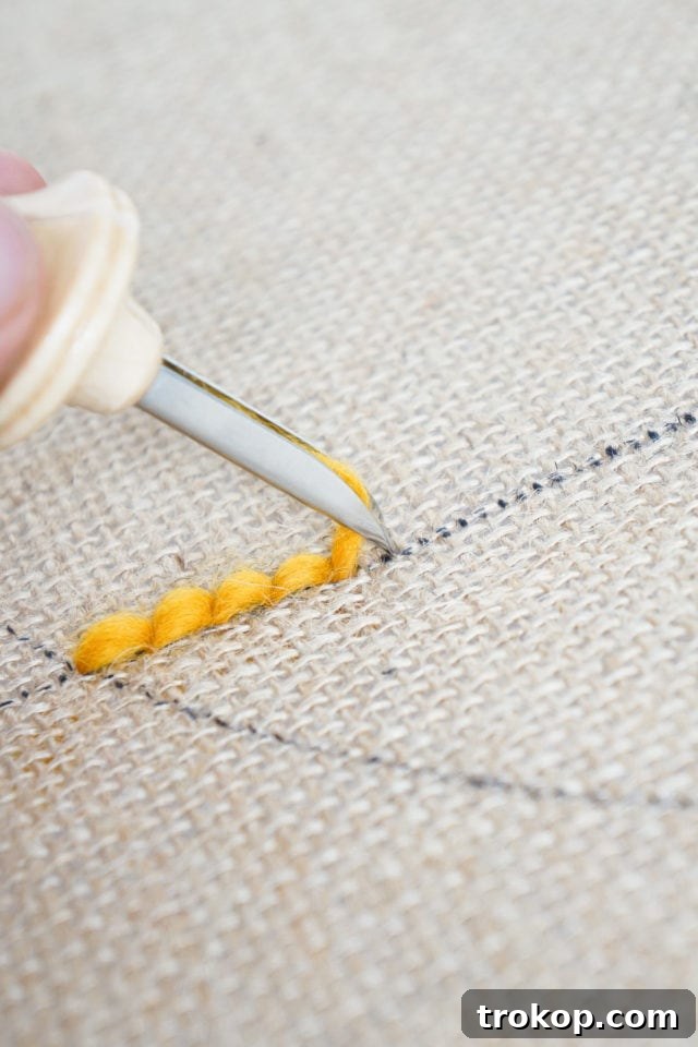 How to Make a Rug Hooked Pillow 11 Step 5: Illustrating the technique of moving the punch needle between stitches on the burlap.