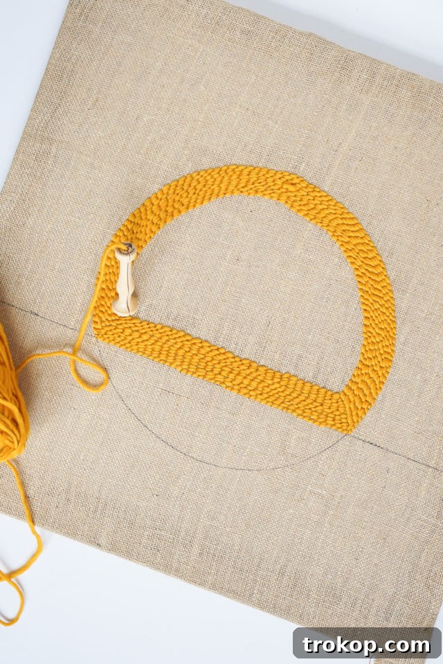 How to Make a Rug Hooked Pillow 12 Step 6: Showing a completed section of rug hooking, where a design shape is fully filled with yarn loops.