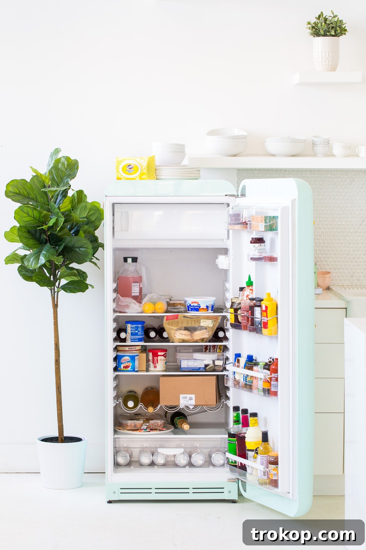 6 Unexpectedly Delightful Hacks for a Sparkling Spring Fridge 2 Before shot of a cluttered and messy refrigerator interior