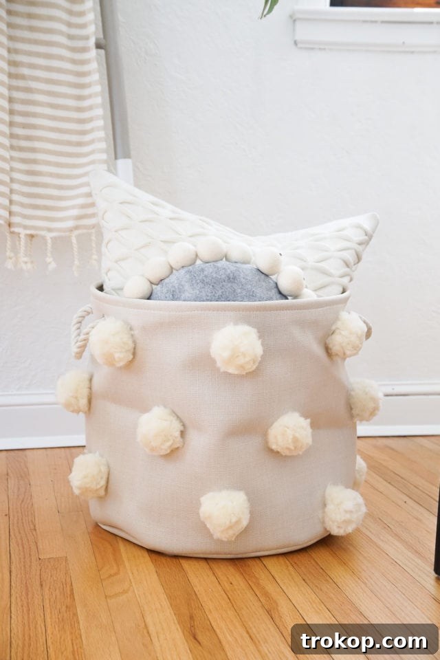 Fluffy DIY pom pom bin styled in a modern neutral room.