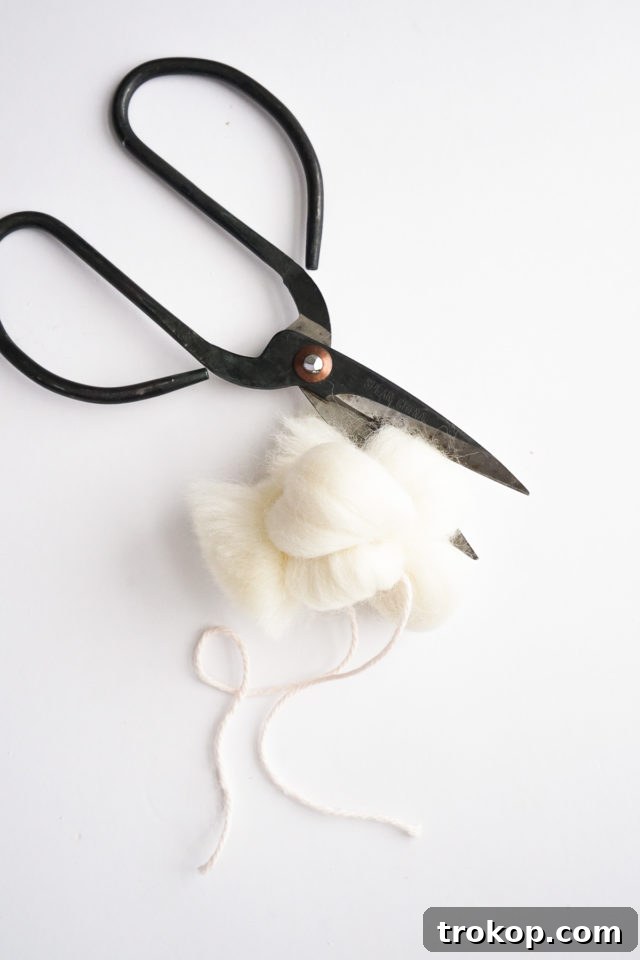 Cutting the loops of the pom-pom and fluffing it out.