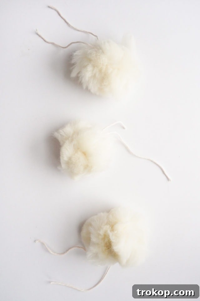 Collection of finished fluffy pom-poms ready for attachment.