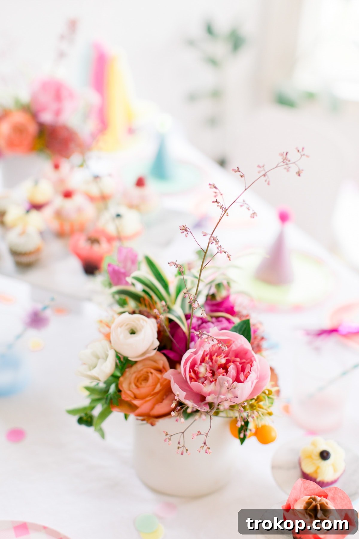 A close-up of the charming pink gingham plates and a paper fan garland from Oh Happy Day, showcasing the delightful pattern mixing at the party.
