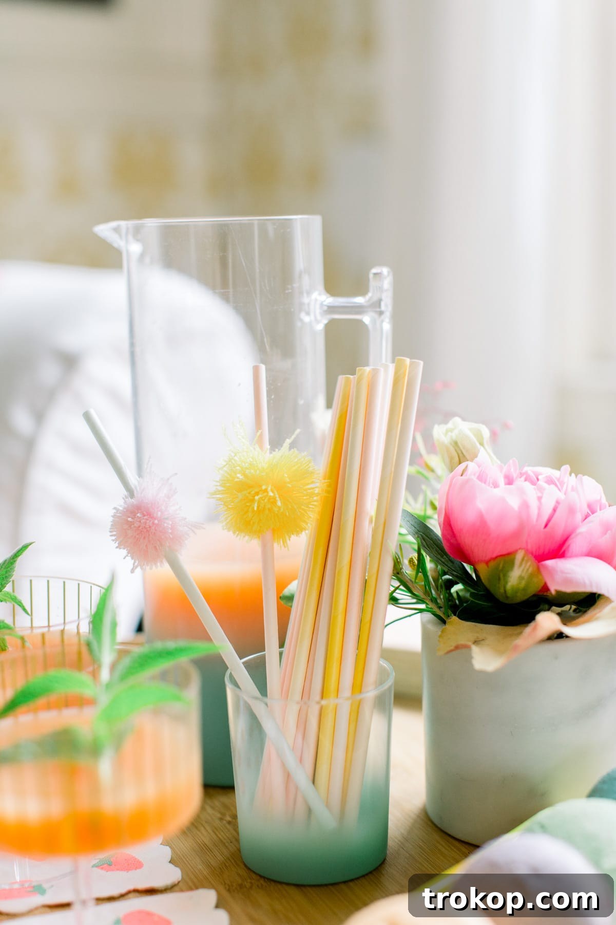 A charming display of party snacks and treats, set amongst colorful pom pom garlands and festive decor, inviting guests to indulge.