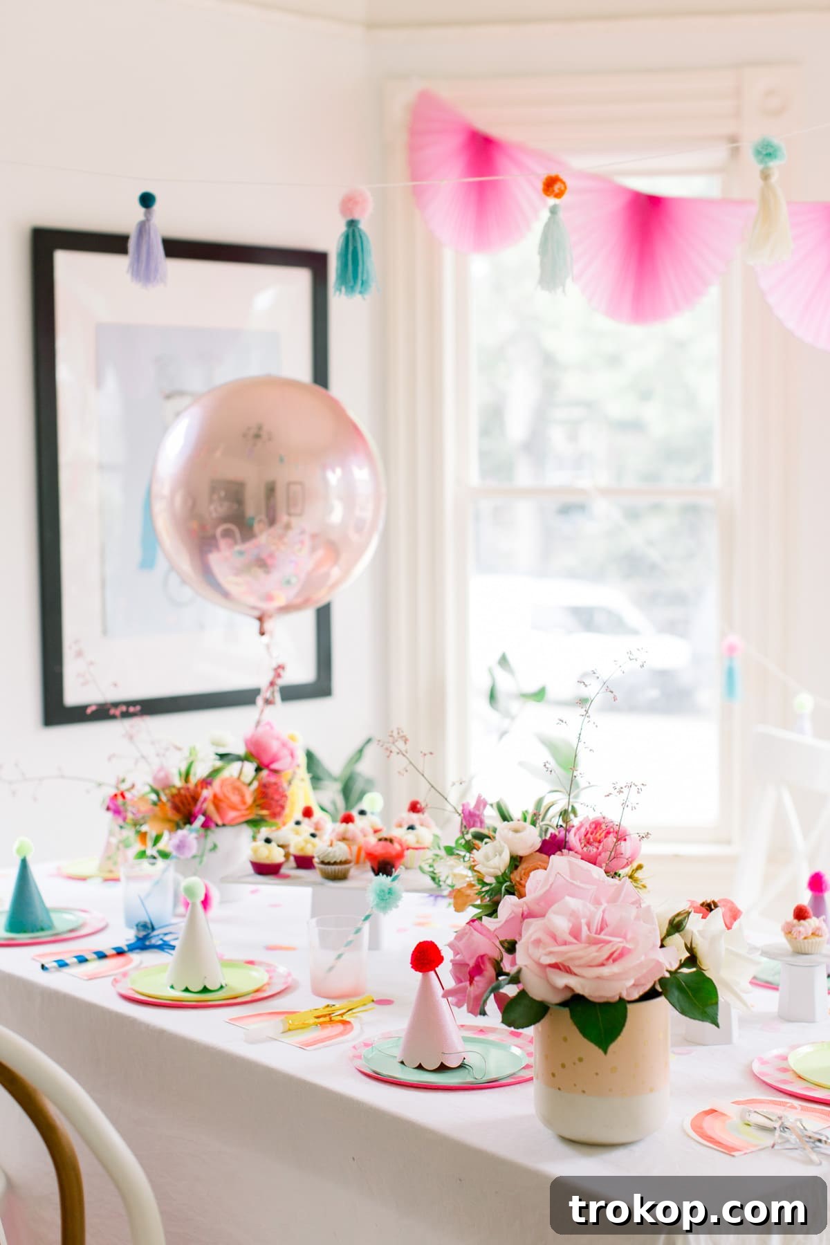 A delightful arrangement of fresh flowers by Seascape Flowers, adding natural beauty and color to the festive pom pom birthday party decor.