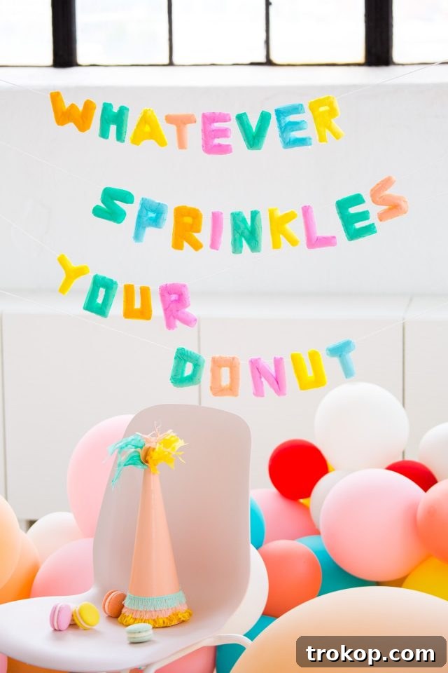 Close-up of a 'Whatever Sprinkles Your Donut' Faux Balloon Banner, highlighting meticulous detail