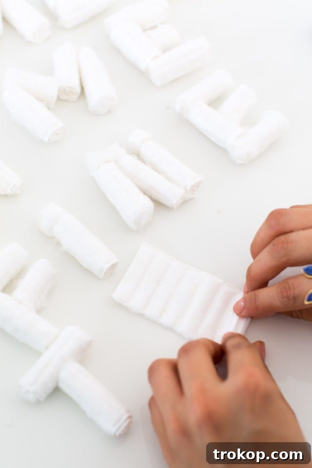 Tutorial step: rolling cotton into place to form letter shapes for the non-deflating faux balloon banner