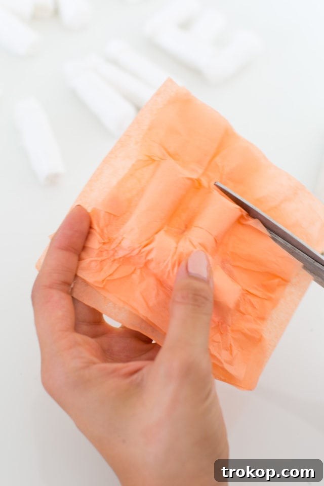 Tutorial step: trimming excess tissue paper around the faux balloon letter for a clean edge