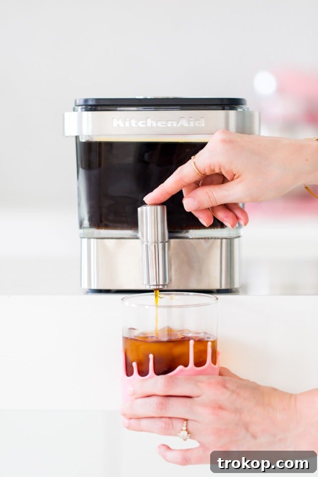 The Ultimate Cereal Milk Cold Brew 6 Water being poured over coffee grounds in a KitchenAid cold brew maker, by top Houston lifestyle blogger Ashley Rose of Sugar and Cloth