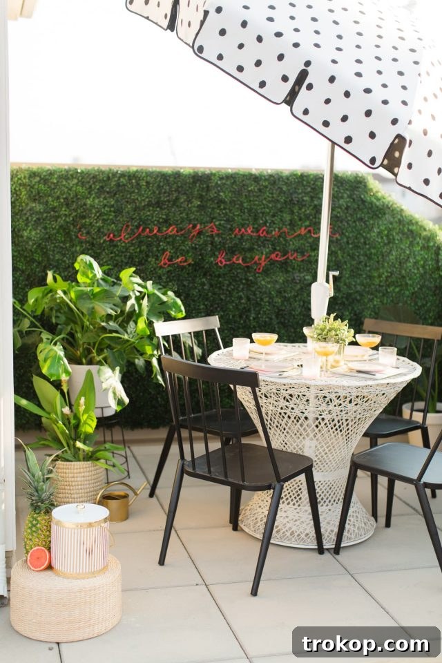 Lush Greenery Meets Neon Radiance 19 Finished faux boxwood wall with DIY neon sign at night by Ashley Rose of Sugar & Cloth