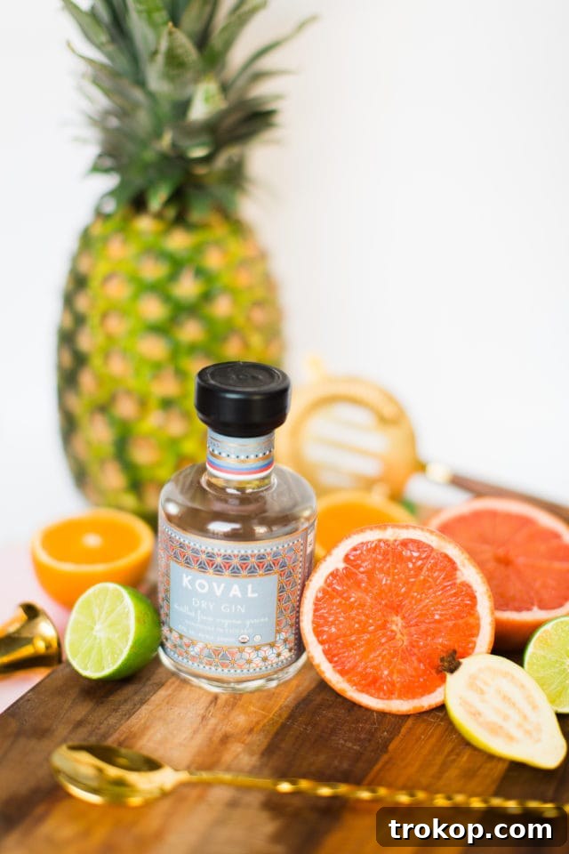 Two glasses of the Immunity Boosting Citrus Gin Punch, garnished with fresh fruit, on a stylish tray, ready to be served.