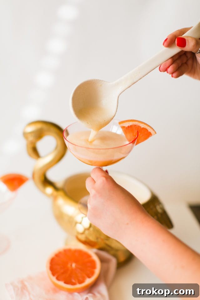 A refreshing glass of Immunity Boosting Citrus Gin Punch, beautifully garnished with a pineapple wedge and citrus slices.