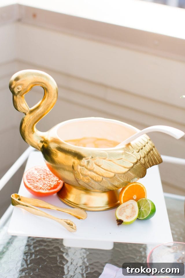 Overhead shot of a punch bowl filled with the vibrant Citrus Gin Punch, garnished with fresh fruit, ready for serving.