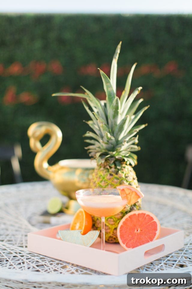 A hand reaching for a glass of the Immunity Boosting Citrus Gin Punch from a beautifully arranged serving tray, indicating an enjoyable moment.