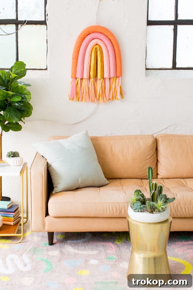 DIY Rainbow Art Wall Hanging, a vibrant and budget-friendly home decor project using pool noodles and crepe paper. Perfect for adding color to any room, by Ashley Rose of Sugar and Cloth.