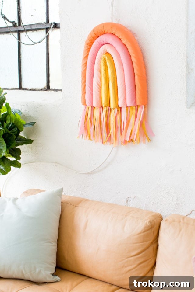 Close-up of the DIY Rainbow Art Wall Hanging showcasing the vibrant colors and textured crepe paper wrapping over pool noodles.