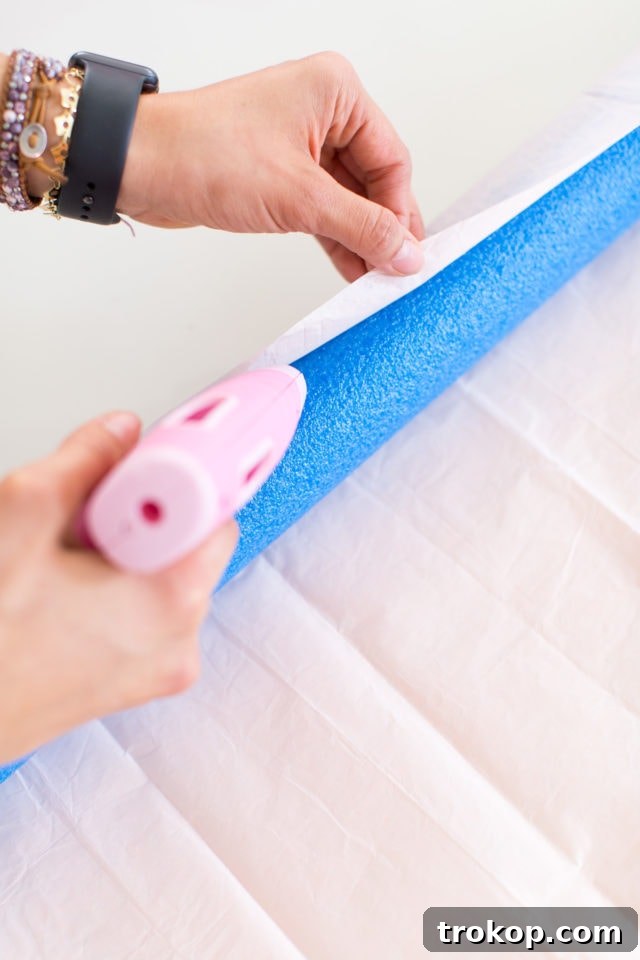 DIY Rainbow Art Wall Hanging materials laid out: colorful crepe paper, scissors, hot glue gun, and pool noodles.