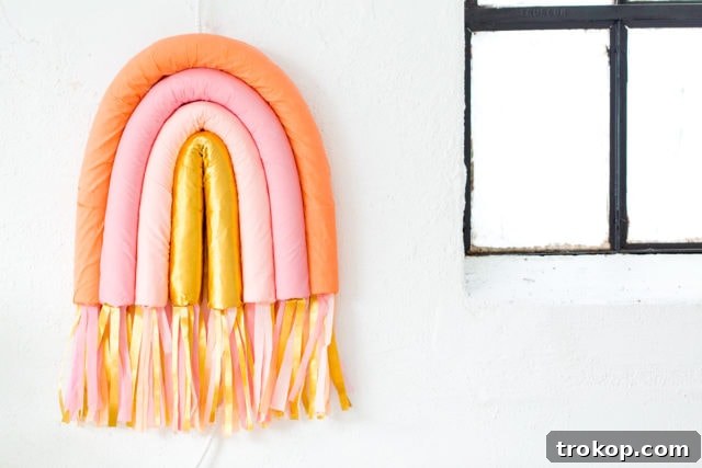 The completed DIY Rainbow Art Wall Hanging with vibrant colors and fringe, ready to be displayed.