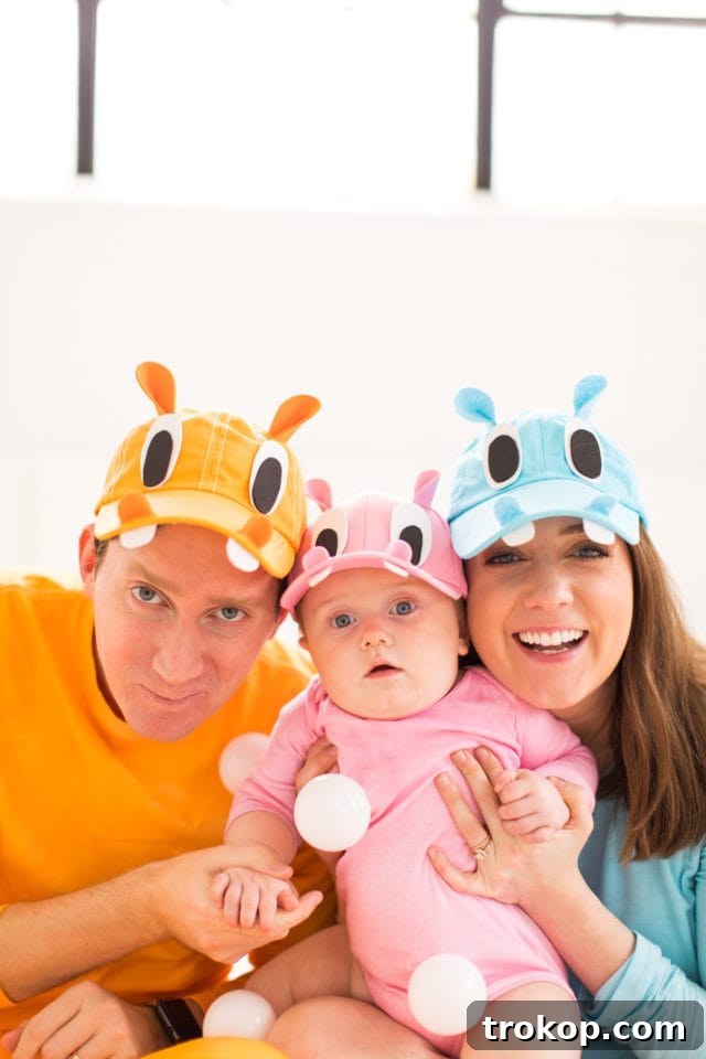Our Handmade Hungry Hippo Crew 9 The full family, including the baby in the specially designed walker, proudly showcasing their complete DIY Hungry Hungry Hippos costumes. This vibrant group shot highlights the collective effort and success of creating a unique and fun family Halloween costume idea.