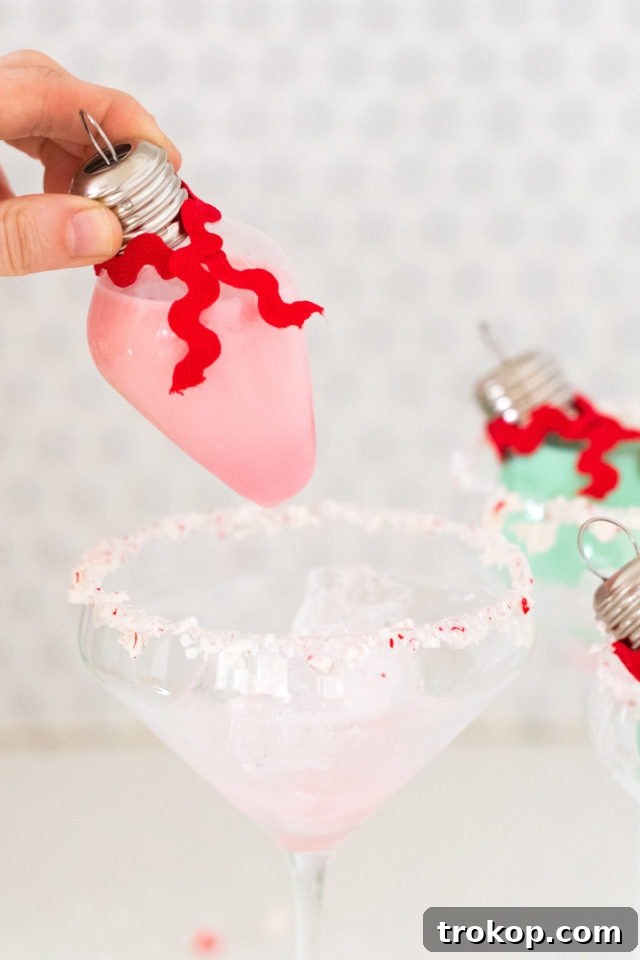 Homemade Holiday Cocktail Baubles 4 Assortment of unique holiday cocktails in clear ornaments with festive garnishes.