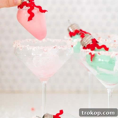 Pink and mint green cocktails with rumchata in ornament bulbs.
