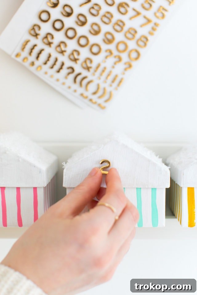 Colorful Village Advent Calendar Craft for Kids 7 Applying numbers to DIY advent calendar houses