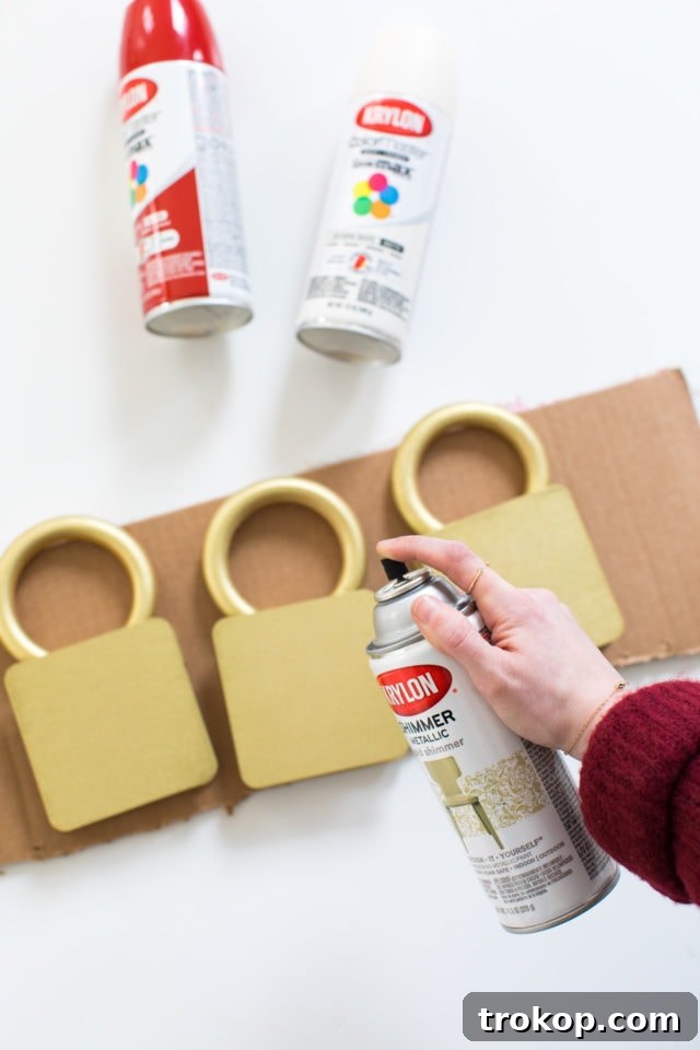 Spray painting the golden tops of the jumbo Christmas light bulbs