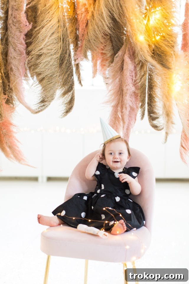 Gwen in a party hat posing in front of the Pampas Grass DIY Photo Backdrop