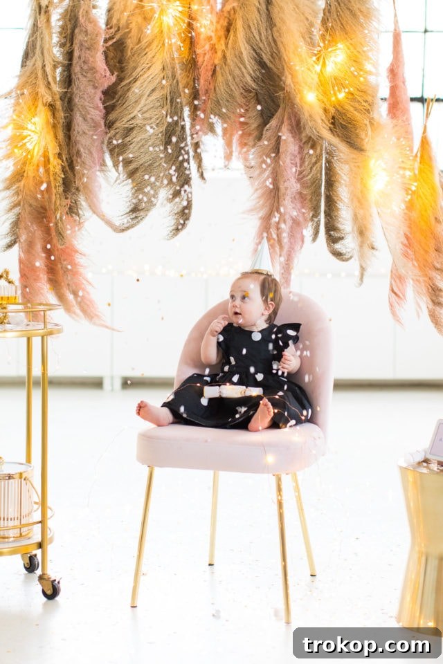 Gwen posing in front of the Pampas Grass DIY Photo Backdrop with confetti