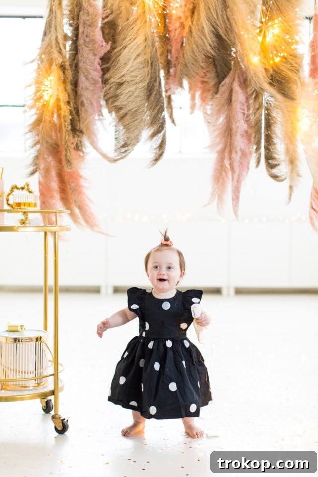 Gwen posing in front of the completed Pampas Grass DIY Photo Backdrop