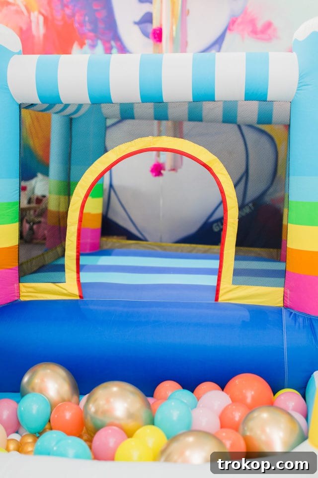 Rainbow bounce house, a fantastic entertainment idea for a first birthday party by Sugar & Cloth