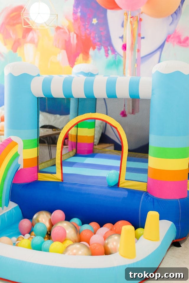 A vibrant rainbow bounce house purchased from Amazon, used for Gwen's first birthday party by Sugar & Cloth