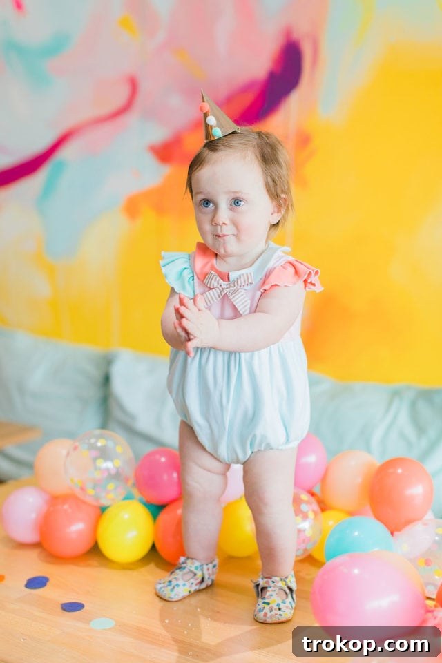 A festive first birthday party setup with colorful decorations and food by Sugar & Cloth